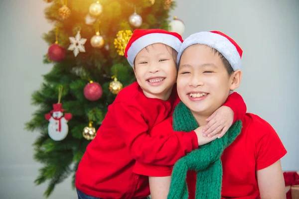 Klein aziatisch meisje knuffelen haar broer en samen glimlachen in huis — Stockfoto