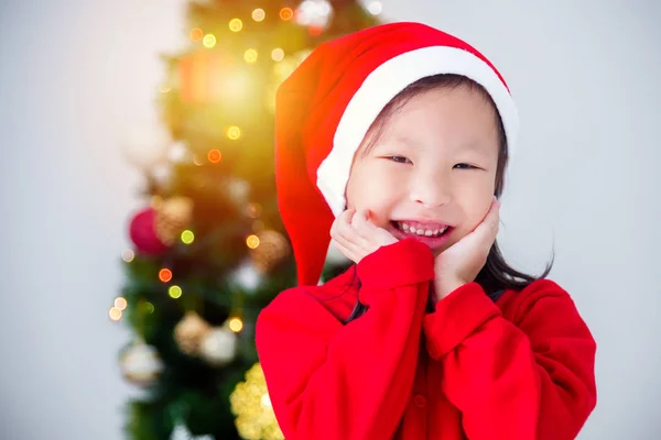 Klein Aziatisch meisje draagt kerstman hoed en glimlacht — Stockfoto