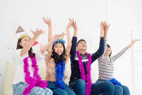 Groep van gelukkige tiener Handen omhoog en geniet van het gooien van kleurrijke confetti met vrienden Stockafbeelding