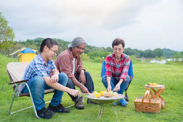 Группа семьи гриля сладкая кукуруза на плите в кемпинге, все чувствуют себя счастливыми . — стоковое фото