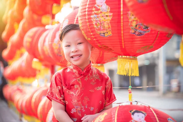 Liten asiatisk flicka klädd i kinesisk treditionell kostym stående med röd lykta och leende — Stockfoto