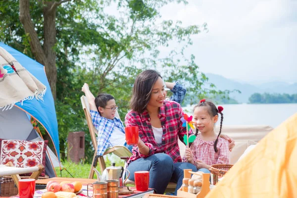 Niña jugando molino de viento con su madre en el camping . — Foto de Stock