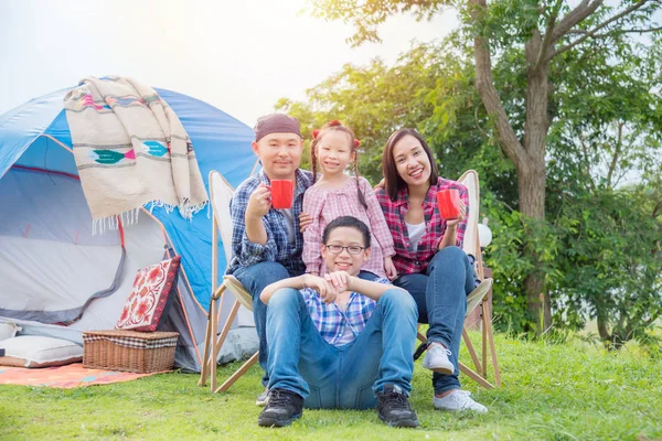 Familia feliz sentado en el camping y sonreír juntos . — Foto de Stock