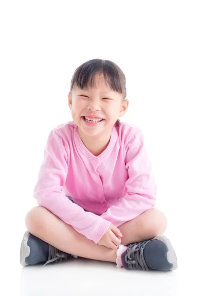 Glücklich kleine asiatische Mädchen sitzen und lächeln über weiß . — Stockfoto