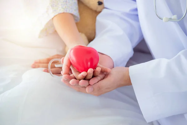 Manos Paciente Infantil Médico Masculino Sosteniendo Bola Roja Forma Corazón — Foto de Stock