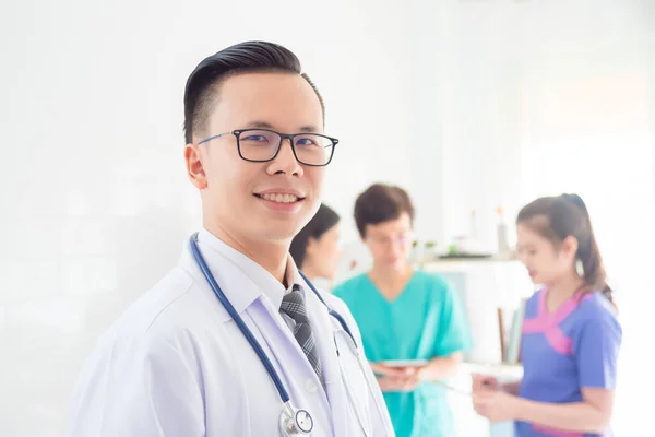 Joven Asiático Médico Blanco Abrigo Sonriendo Cámara Con Equipo Pie — Foto de Stock