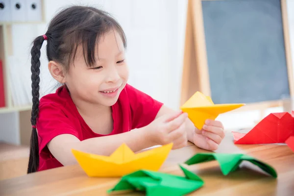 小さなアジアの女の子は紙飛行機をやって学校で紙折りから — ストック写真