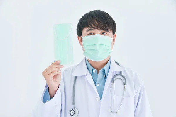 Asian Male Doctor Wearing Medical Mask Holding Mask White Background — Stock Photo, Image