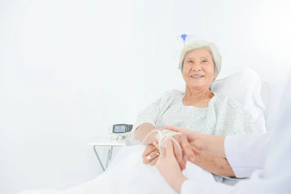 病院で医者の手を握り笑顔で幸せシニアアジア女性患者 — ストック写真