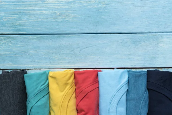 Gros plan de vêtements colorés roulés sur fond de table bleue — Photo