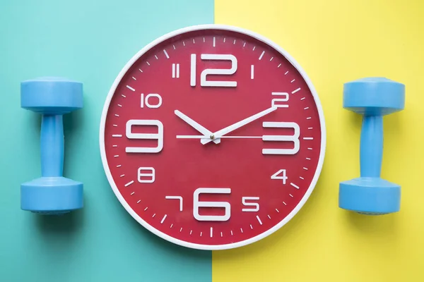 Ώρα για άσκηση ρολόι και αλτήρα με πολύχρωμο φόντο — Φωτογραφία Αρχείου