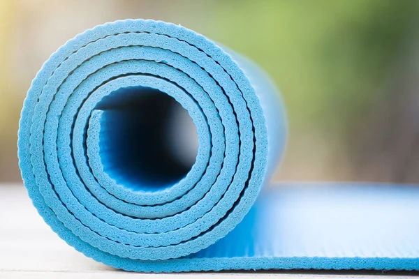 Primer plano de estera azul del yoga en la mesa, deporte y cóncavo sano — Foto de Stock