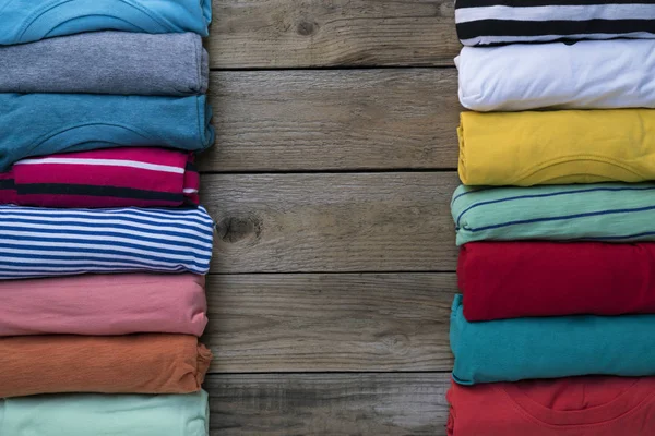 Крупным планом разноцветной одежды на фоне деревянного стола — стоковое фото