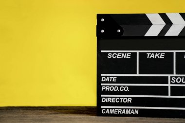 sarı arka plana sahip ahşap masa üzerinde film clapper; Film, cinem