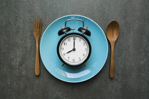 Élelmiszer óra kanalat és a villát, egészséges élelmiszerek fogalmát, a fekete backgro — Stock Fotó