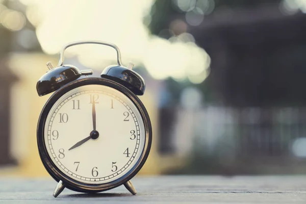 Reloj despertador retro en mesa de madera, a las 8 de la mañana — Foto de Stock