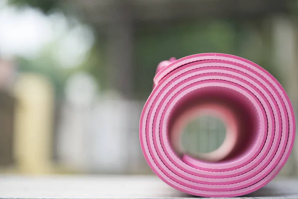 pink yoga mat on the table, sport and healthy concept