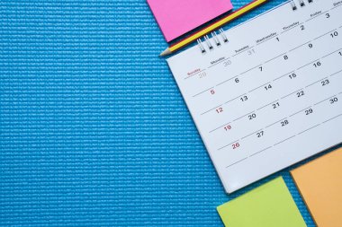 Egzersiz, mavi yoga mat arka plan üzerinde takvim için zaman