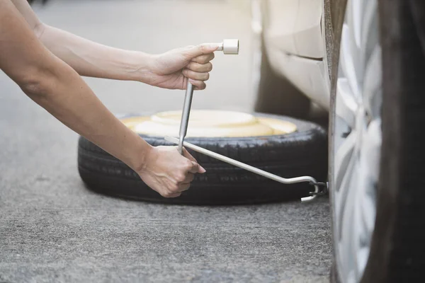 Mujer cambiando de rueda en una carretera, fijar y reparar el concepto de coche — Foto de Stock