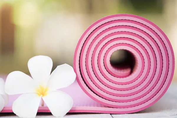 close up of pink yoga mat and flower on the table, sport and hea