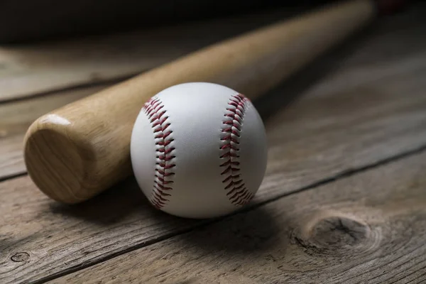 Baseball und Baseballschläger auf hölzernem Tischhintergrund, Nahaufnahme — Stockfoto