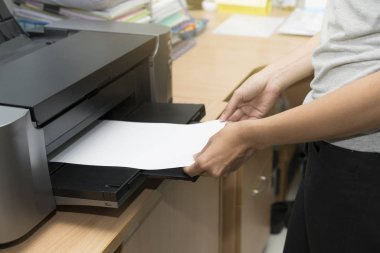 kadın fo beslemek için bekleyen bir yazıcı tepsisine kağıt sayfaya ekleme