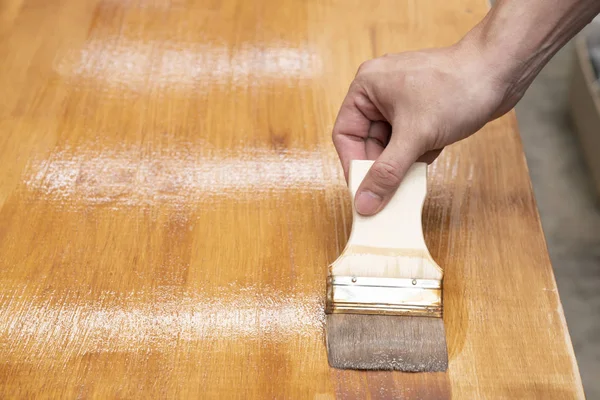 Applying protective varnish on a wooden furniture — Stock Photo, Image