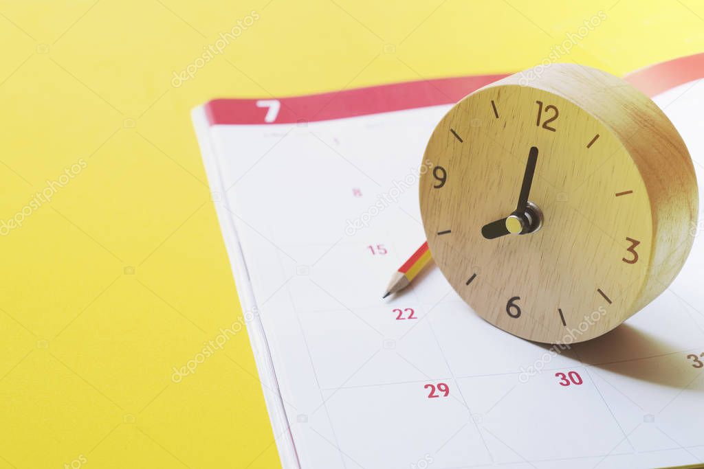 close up of calendar, clock and pencil on yellow background plan