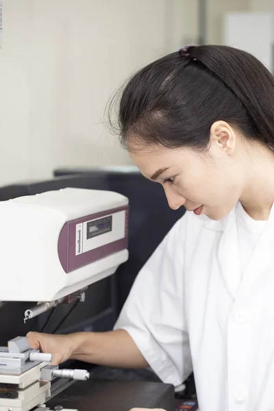 Jonge Aziatische vrouw ingenieur instellen en testen van de machine in het lab — Stockfoto