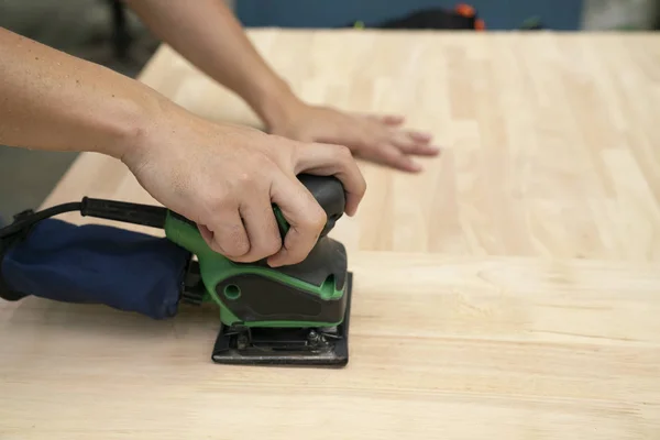 Charpentier frottant le panneau de bois dans l'atelier, bricolage et réparation c — Photo