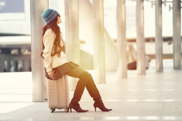 공항에서 여행 가방에 앉아 부츠를 신고 있는 여성 , WA — 스톡 사진