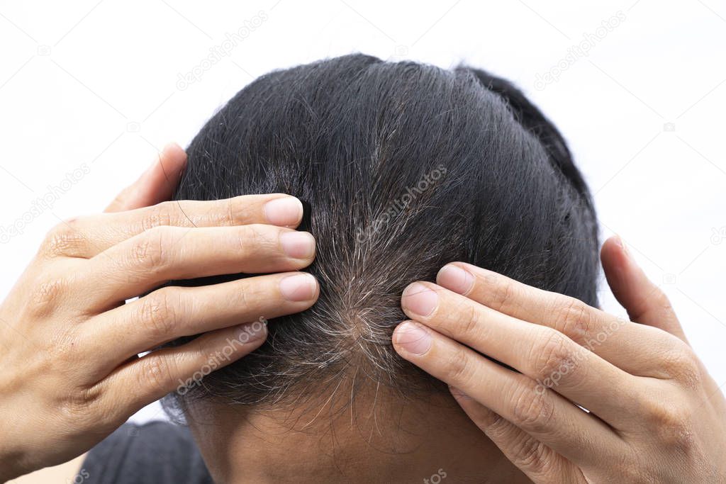 Young woman shows her gray hair roots on the isolated white back