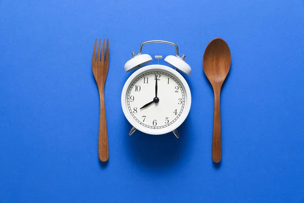 Часы. Концепция здорового питания на синем фоне — стоковое фото