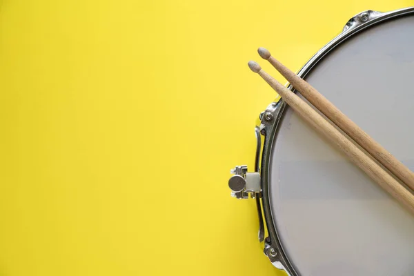 Tambor palo y tambor sobre fondo de mesa amarillo, vista superior, música —  Fotos de Stock