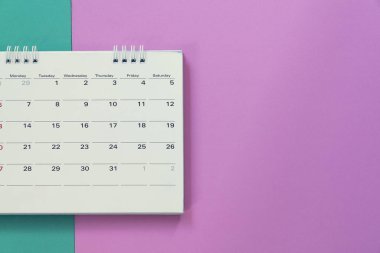 Takvimin yeşil ve pembe masa arkaplanı üzerine kapatılması, iş toplantısı ya da seyahat planlama konsepti