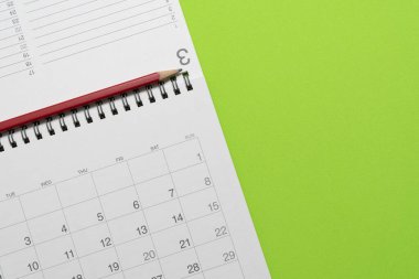 Yeşil masa arkaplanındaki takvim ve kalemi kapat, iş toplantısı ya da seyahat planlama konseptini planla