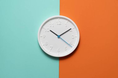 Yeşil ve turuncu renkli masa arkaplanı üzerinde beyaz saat, antika tarzı