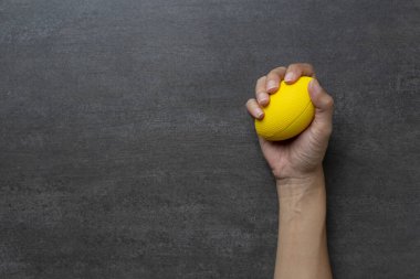 Kadın eli siyah masa arkasında stres topu tutuyor, stres konsepti