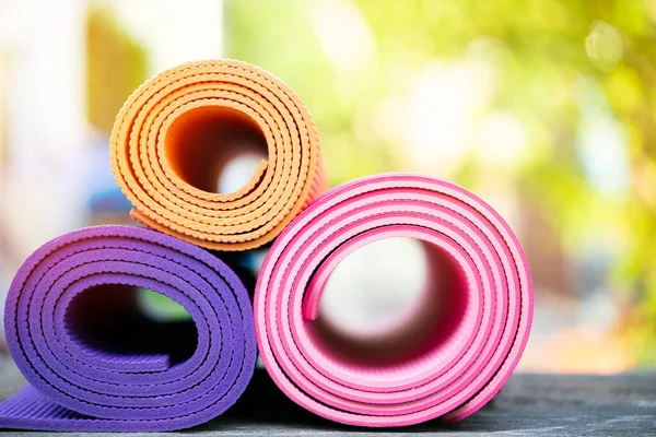 把色彩斑斓的瑜伽垫放在桌上 运动与健康的概念 — 图库照片