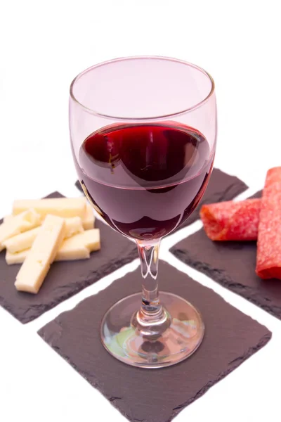 Scheiben Salami und Wein auf Schiefertellern — Stockfoto