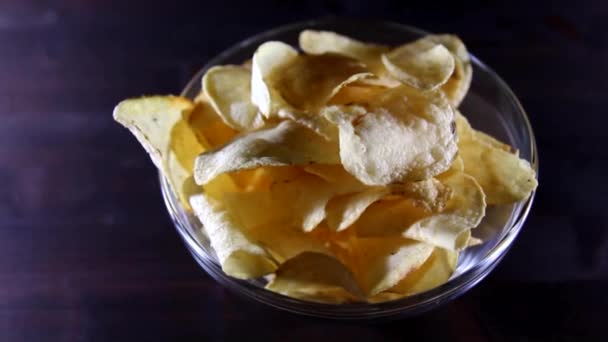 Chips op kom op een houten tafel in langzame rotatie — Stockvideo