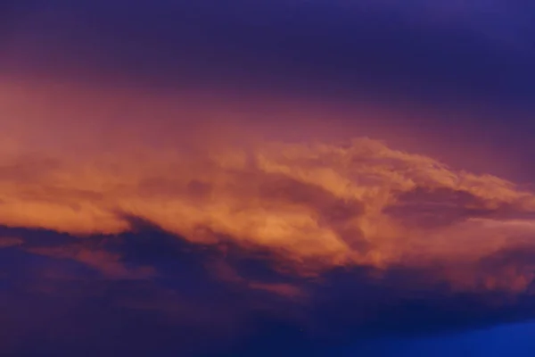 Rosa naranja puesta de sol nubes en el cielo azul profundo — Foto de Stock