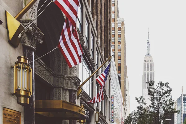 Bandeiras americanas acenando fora de um hotel em Midtown com o Em — Fotografia de Stock