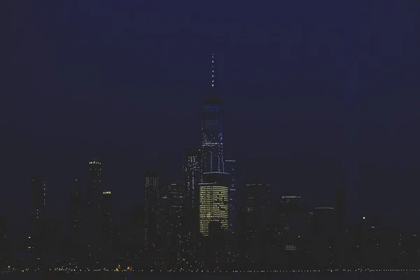 曼哈顿下城的天际线由夜间看到从霍博肯与致敬在光 — 图库照片