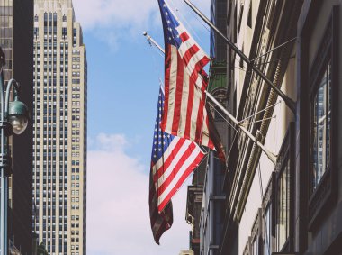 Manhattan'da bir binadan sallayarak Amerikan bayrakları