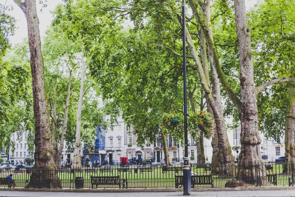 Park with greenery, benches and sculptures in Berkeley Square in — Stock Photo, Image