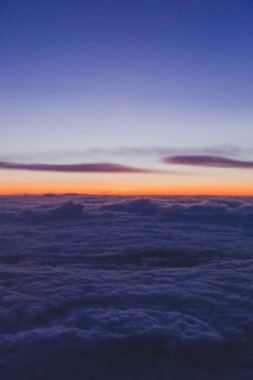 günbatımı pembe ve mor tonları ile uçak pencere kenarı vurdu