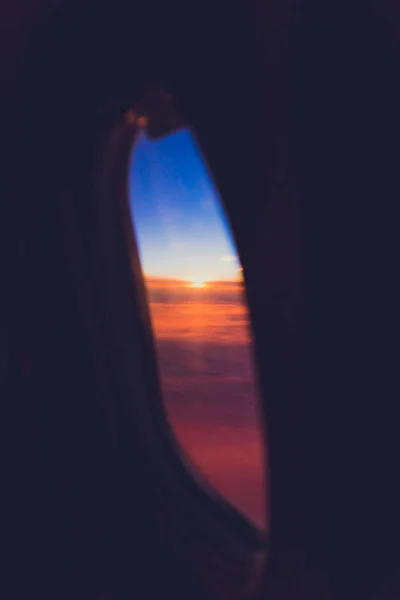 Puesta de sol con tonos rosa y púrpura disparado desde el asiento de la ventana del avión — Foto de Stock