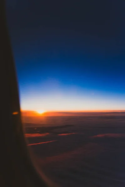 Puesta de sol con tonos rosa y púrpura disparado desde el asiento de la ventana del avión — Foto de Stock