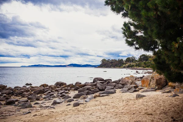 Hobart, Tasmanya ıssız plaj ön planda taşlarla